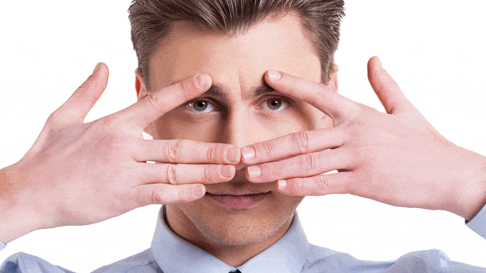 a young man holding hands over face and peeking thru fingers