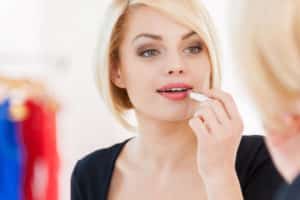 Blonde woman with beautiful skin applying makeup